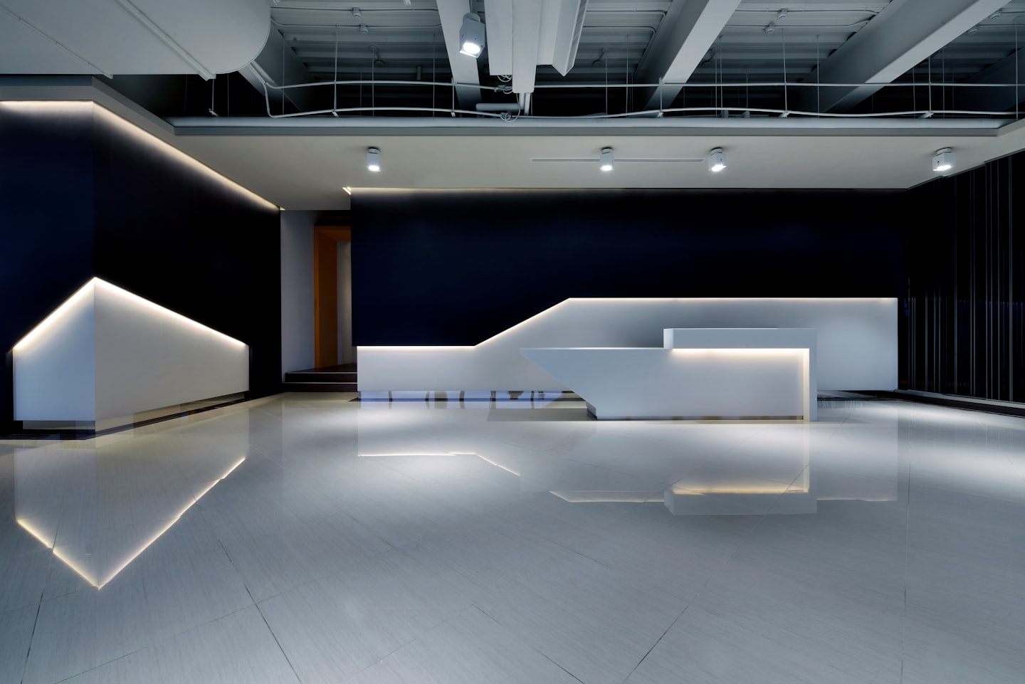Moderna reception con illuminazione calda su pareti blu navy.