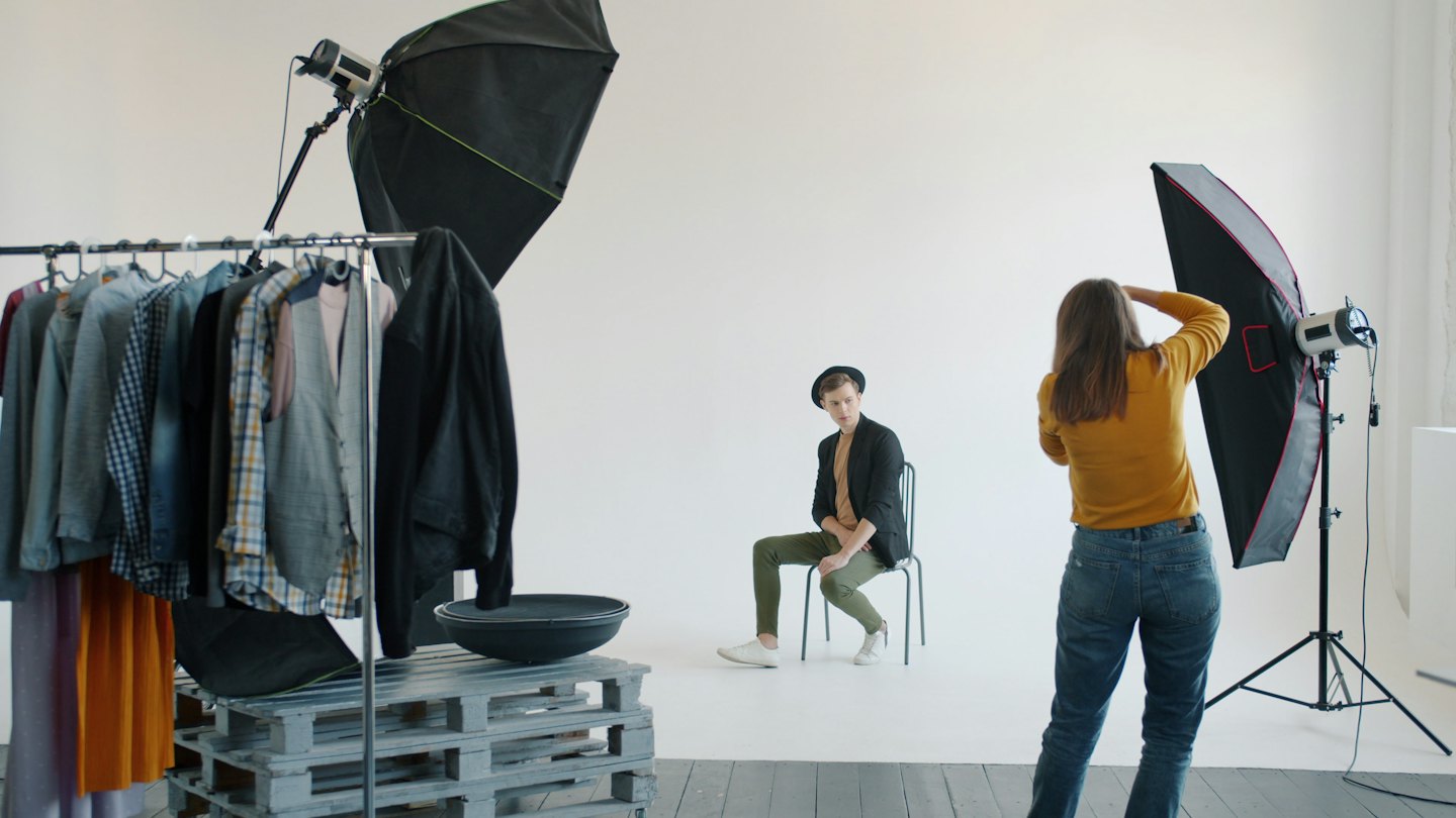 Fotografo che dirige un modello maschile durante uno shooting in studio.